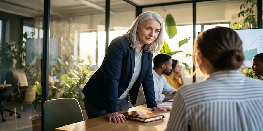 An attentive leader leaning forward to actively listen to a team member in a meeting