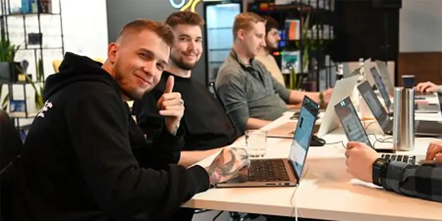 A team of professionals collaborating around a laptop in a modern office space