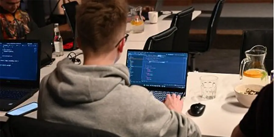 Close-up of a person typing on a laptop keyboard while studying