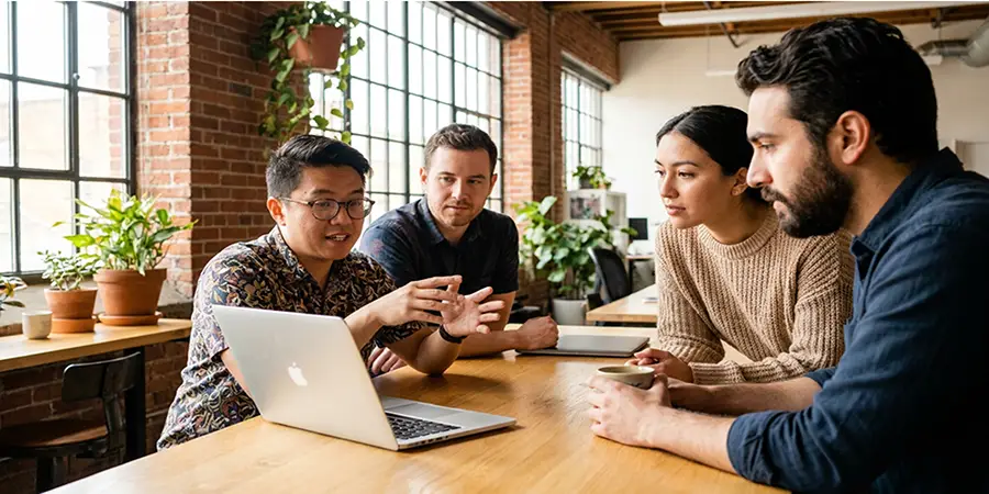 A team of software developers having a calm, collaborative discussion in a modern office, demonstrating active listening and good communication skills.