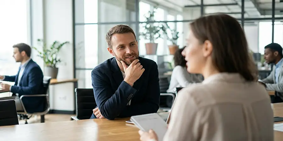 A professional candidate demonstrating active listening during a job interview