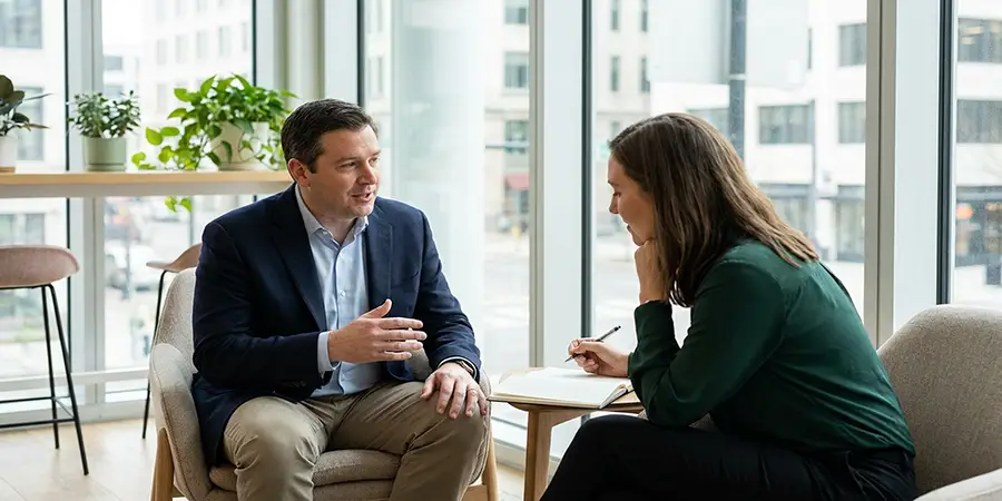 Two professionals engaged in a focused, one-to-one leadership coaching session in a modern office