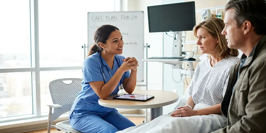 Nurse calmly explaining a care plan to a patient and family