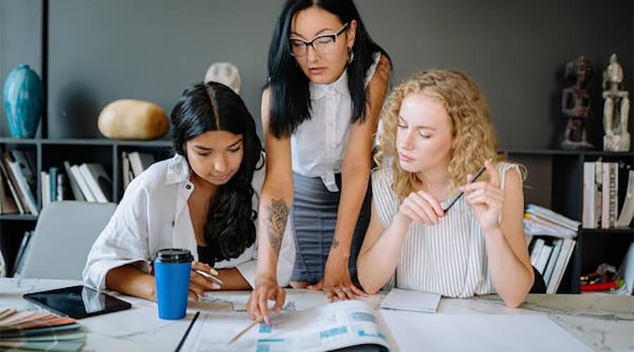 Group of young women working on a design.
