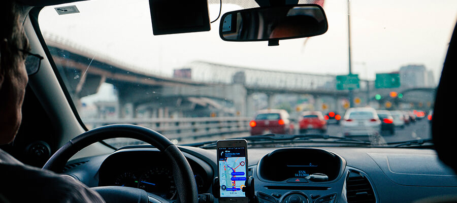 View of busy highway from a car with driver and sat nav.