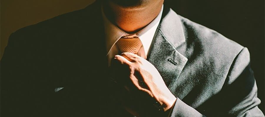 Man in suit straightening his tie.