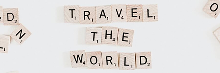 'Travel the world' spelt out in scrabble tiles.