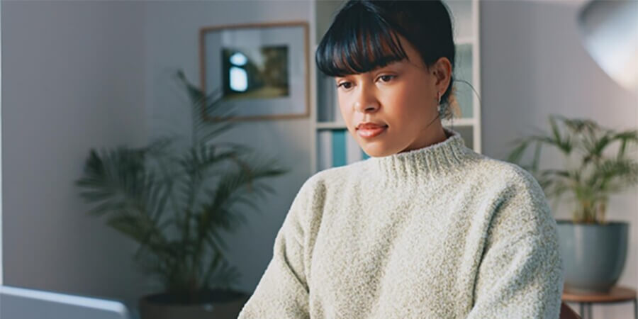Woman in a fluffy jumper focusing on something.