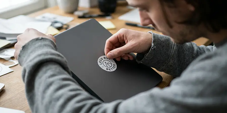 A person practicing visual communication by carefully focusing on a simple sticker design layout